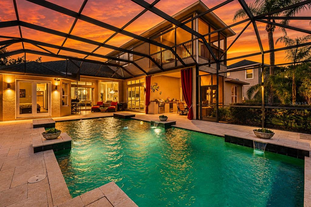 A swimming pool with water features sits on a patio enclosed by a screened lanai — 1568 HICKORY VIEW CIRCLE, PARRISH, FL