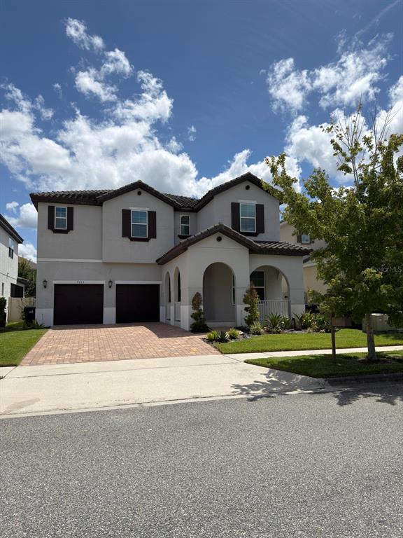 A two-story house with a beige stucco exterior, dark shutters, and a two-car garage — 8713 CRESCENDO AVENUE, WINDERMERE, FL