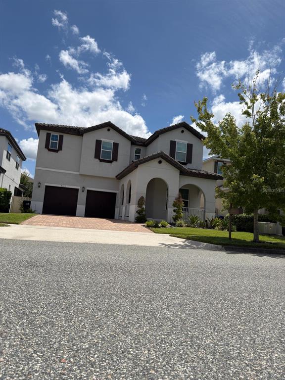A two-story stucco house with a two-car garage and an arched front entryway — 8713 CRESCENDO AVENUE, WINDERMERE, FL