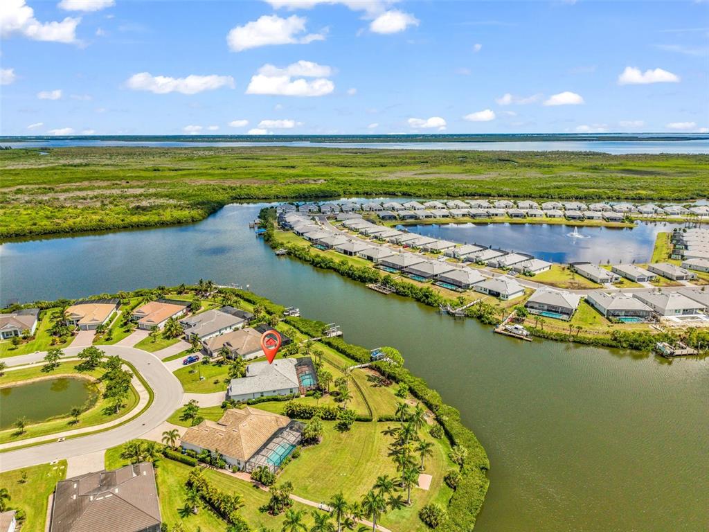 An aerial view shows a waterfront house with a pool in a residential community — 15336 SPANISH POINT DRIVE, PORT CHARLOTTE, FL