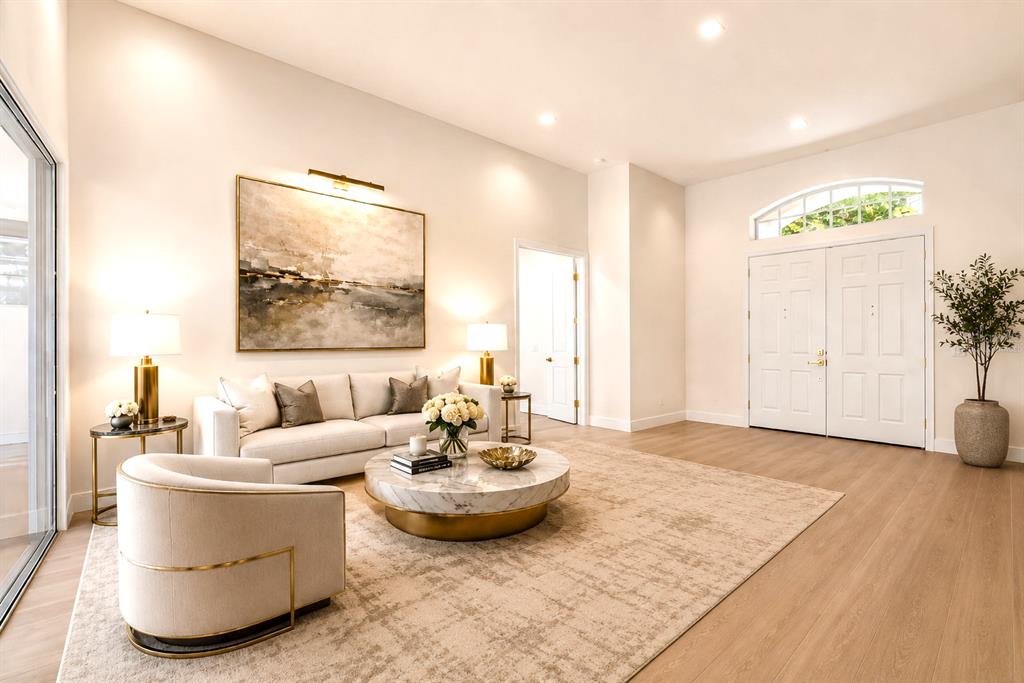 A bright living room features a sofa, round coffee table, and armchair on a rug — 9548 CROWN PRINCE LANE, WINDERMERE, FL