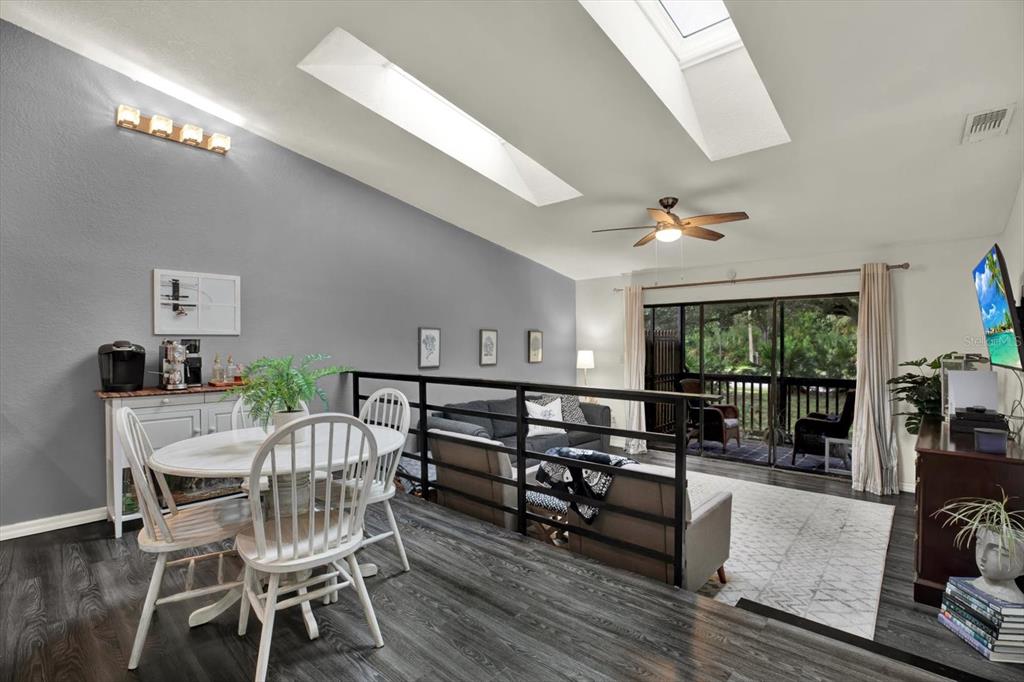 A dining area overlooks a sunken living room with a ceiling fan and skylights — 6311 93RD TERRACE N UNIT 4403, PINELLAS PARK, FL