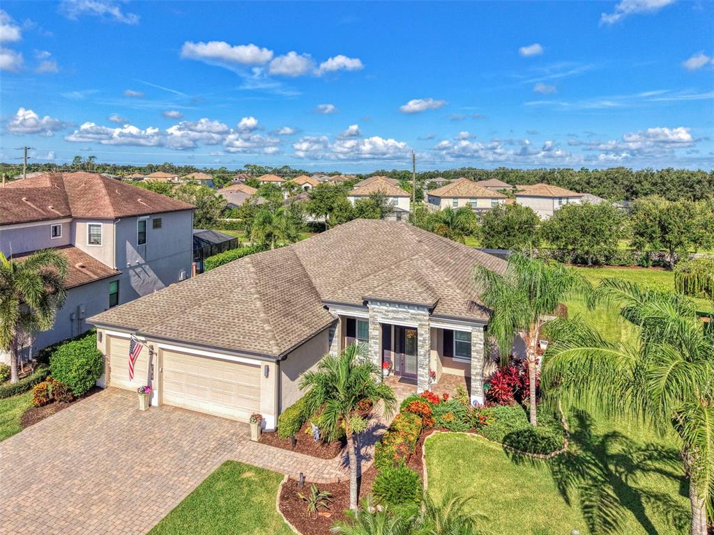 A single-story house with a stone facade, a two-car garage, and a palm tree out front — 708 ROSEMARY CIRCLE, BRADENTON, FL