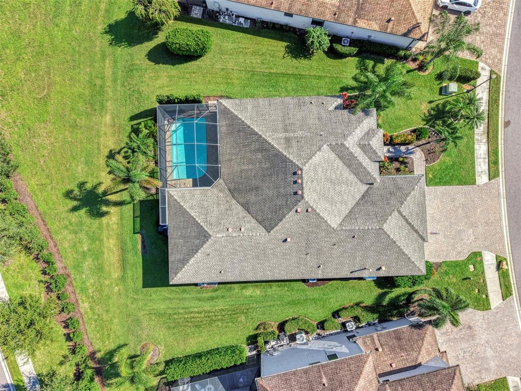 An aerial view of a suburban house with a paved driveway and a tiled roof — 708 ROSEMARY CIRCLE, BRADENTON, FL