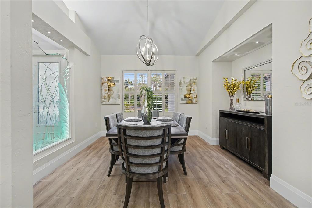 A dining room features a dark wood table, six chairs, a sideboard, and a chandelier — 5186 TALLOWOOD WAY, NAPLES, FL