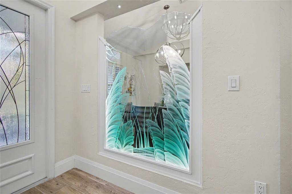 A decorative etched glass panel with a leaf design is mounted on an interior wall — 5186 TALLOWOOD WAY, NAPLES, FL