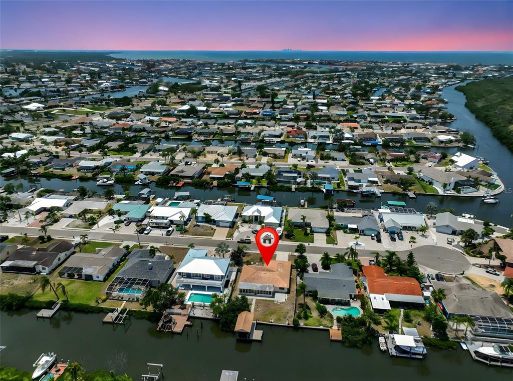 An aerial view shows a waterfront house with a red location pin on a canal — 6523 KING PALM WAY, APOLLO BEACH, FL
