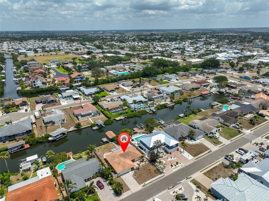 An aerial view shows a residential neighborhood with houses situated along a canal — 6523 KING PALM WAY, APOLLO BEACH, FL