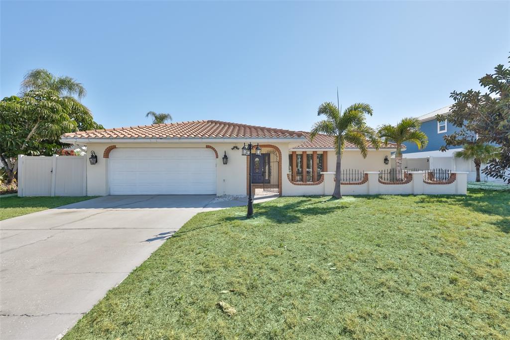 A single-story house with a tile roof, white garage door, and a front lawn — 6523 KING PALM WAY, APOLLO BEACH, FL