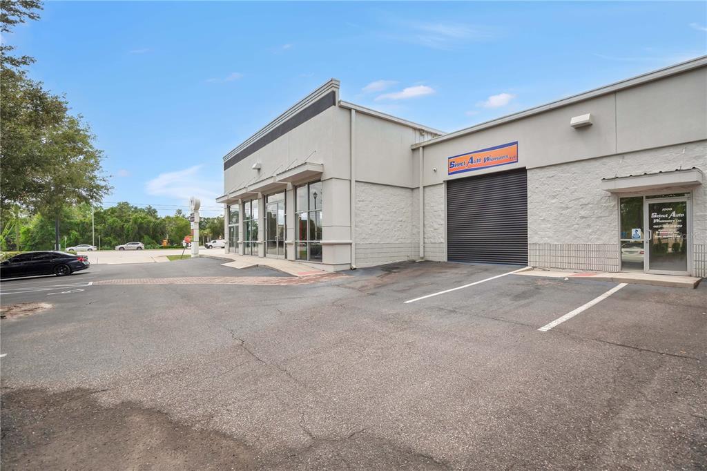 The exterior of a commercial building features a parking lot, a roll-up door, and windows — 2350 S US HIGHWAY 17 92, LONGWOOD, FL