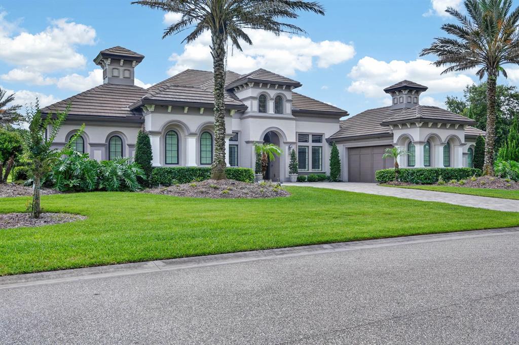 A single-story Mediterranean-style house with a tiled roof, two cupolas, and a paved driveway — 1023 SUDBURY LANE, ORMOND BEACH, FL