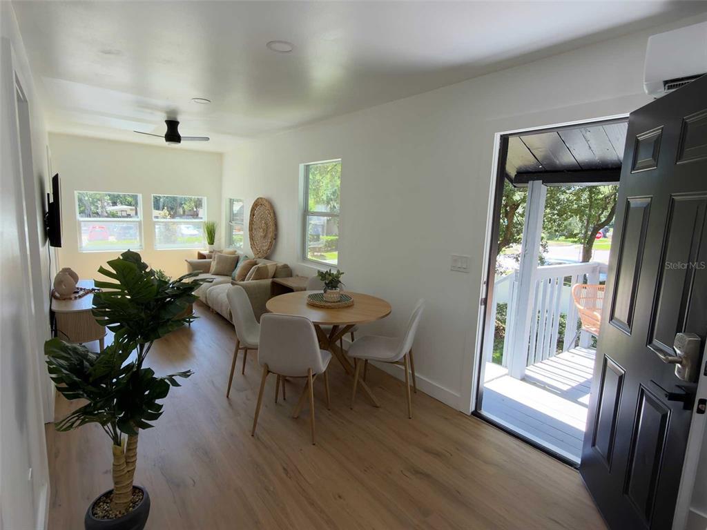 A living and dining area features light wood floors, white walls, and an open doorway — 612 N HAMPTON AVENUE, ORLANDO, FL