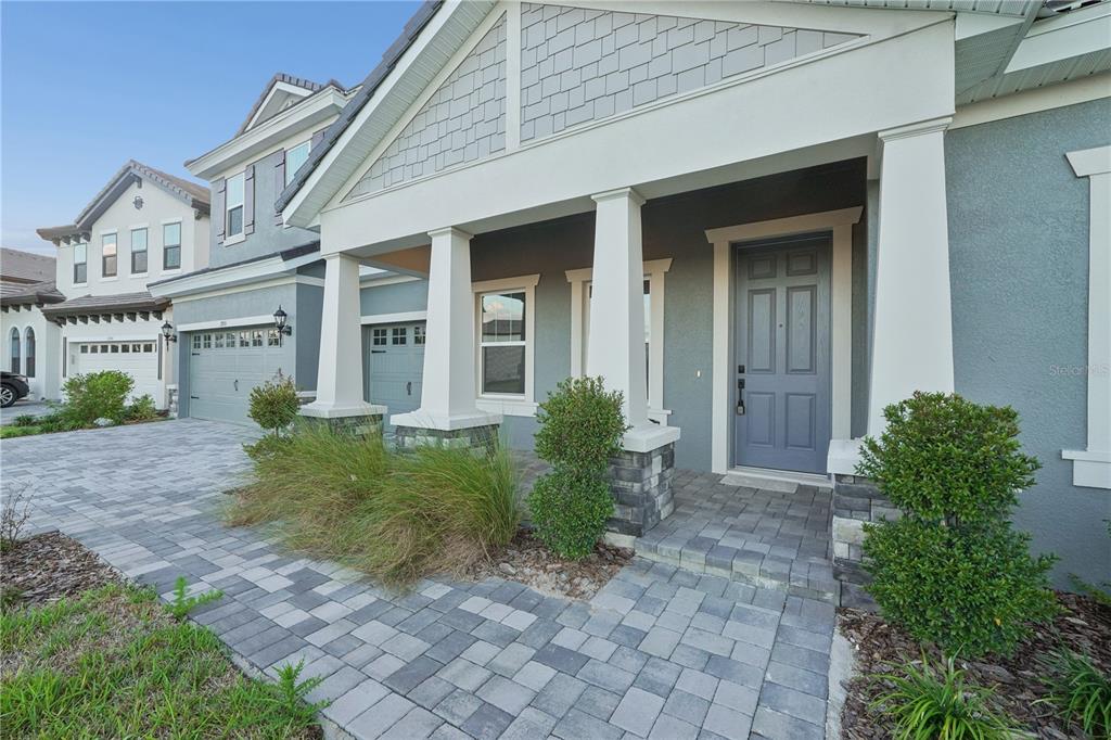 An aerial view shows a two-story suburban house with a gray exterior and tiled roof — 1953 ARCHING BRANCH DRIVE, ZEPHYRHILLS, FL