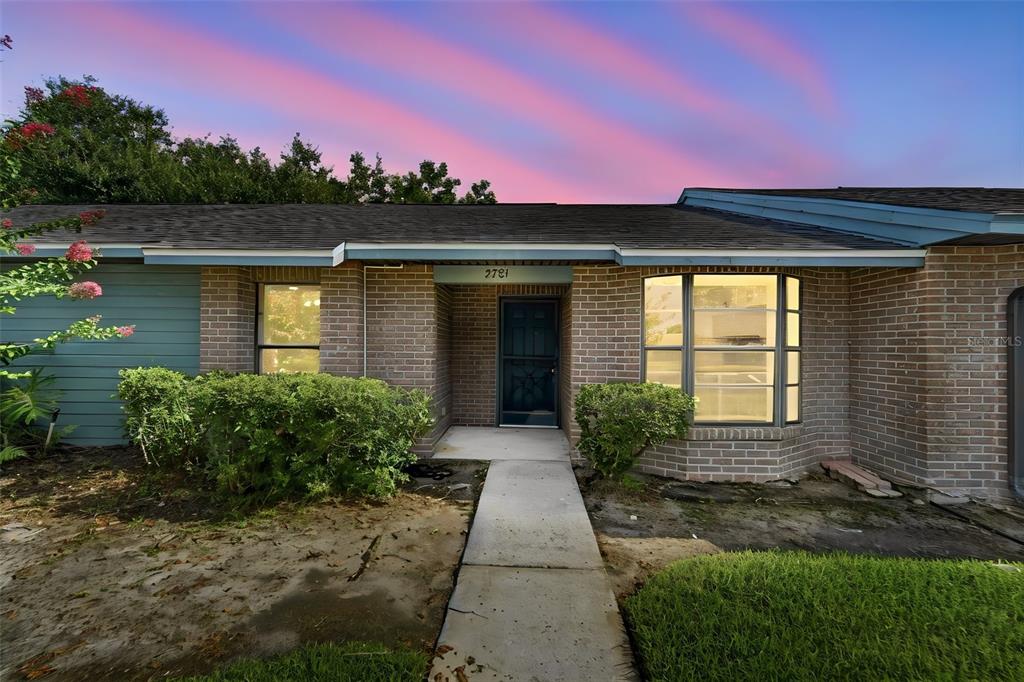 A single-story brick house with a concrete walkway leading to a recessed front door — 2781 KING OAK CIRCLE, ST CLOUD, FL