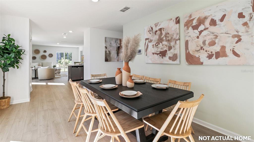 This is a rendering of a dining room featuring a black table and wooden chairs — 73 FLAGSTICK LANE, BUNNELL, FL