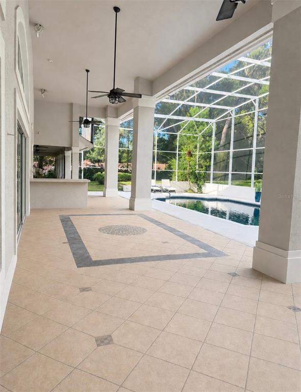 A large house with a screened-in pool enclosure sits on a grassy lot with trees — 950 SWEETWATER CLUB BOULEVARD, LONGWOOD, FL