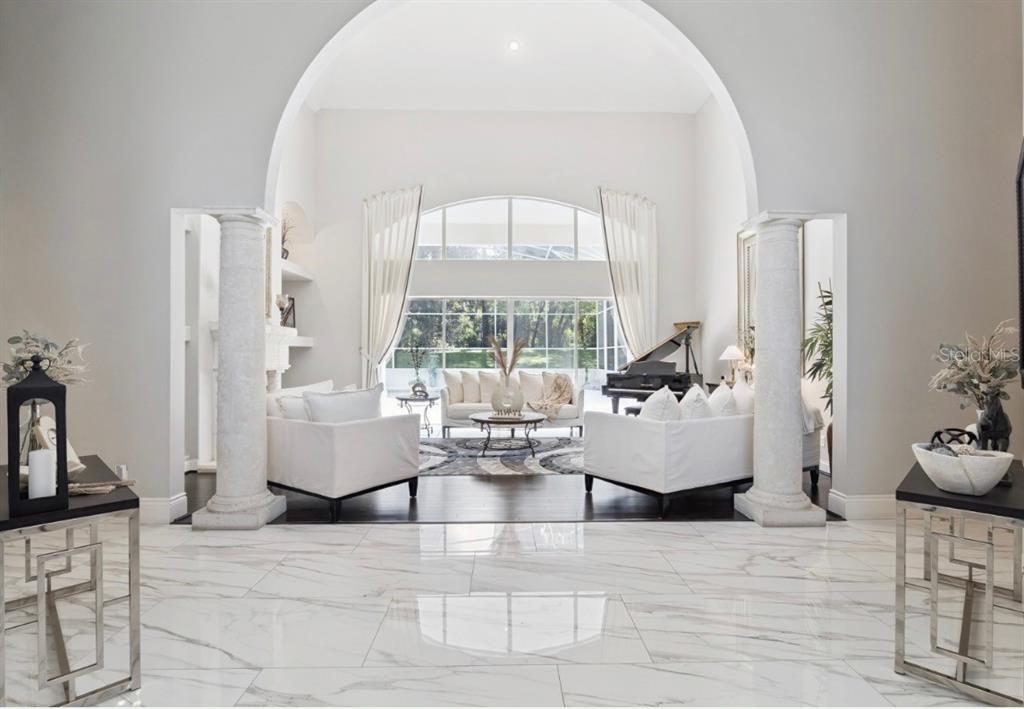 A swimming pool with an attached spa is enclosed by a white screen cage — 950 SWEETWATER CLUB BOULEVARD, LONGWOOD, FL