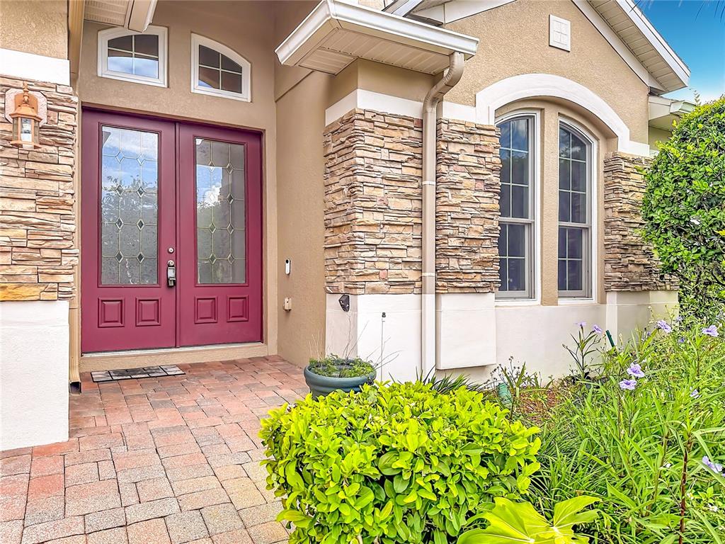 A front entrance features double doors, stone veneer accents, and a brick paver walkway — 2432 EMERALD ROSE WAY, APOPKA, FL