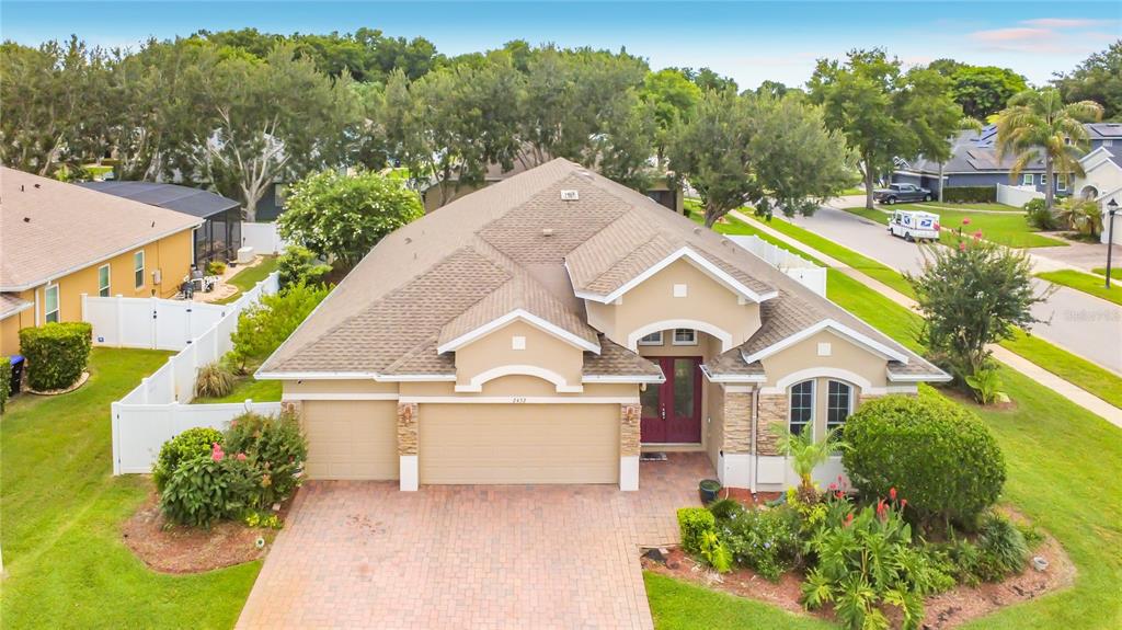 An aerial view of a single-story suburban house with a tan exterior and brick driveway — 2432 EMERALD ROSE WAY, APOPKA, FL