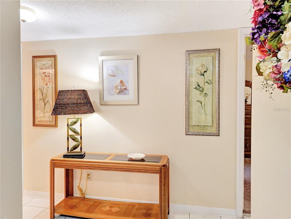 A wooden console table with a lamp sits against a wall decorated with three framed pictures — 700 MIDWAY DRIVE UNIT B, OCALA, FL
