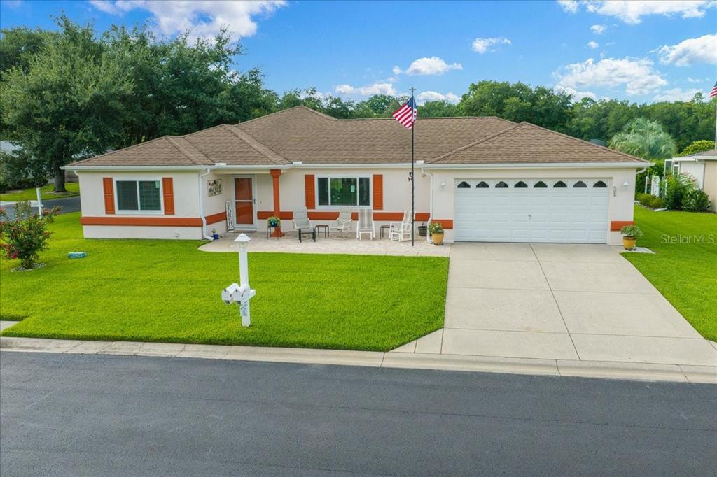 A single-story house with a beige exterior, orange trim, a two-car garage, and a lawn — 11675 SW 140TH LOOP, DUNNELLON, FL
