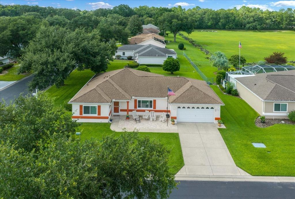 An aerial view of a single-story house with a brown roof, white garage, and front patio — 11675 SW 140TH LOOP, DUNNELLON, FL