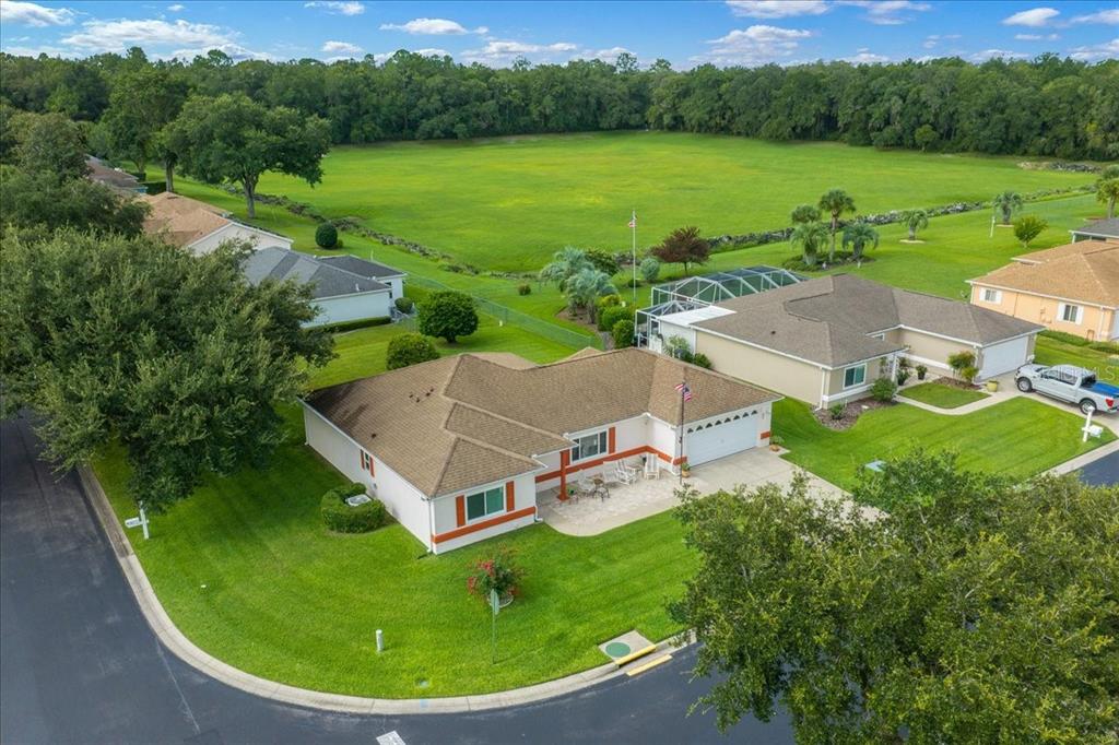 An aerial view shows a suburban house with a brown roof and a large grassy backyard — 11675 SW 140TH LOOP, DUNNELLON, FL