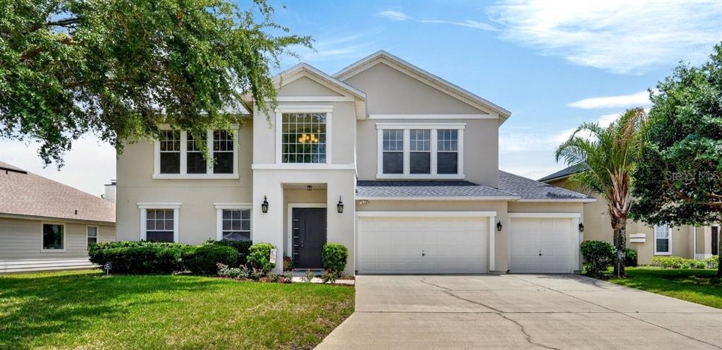 A two-story suburban house with a beige exterior, a three-car garage, and a front lawn — 3016 TOWER OAKS DRIVE, ORANGE PARK, FL