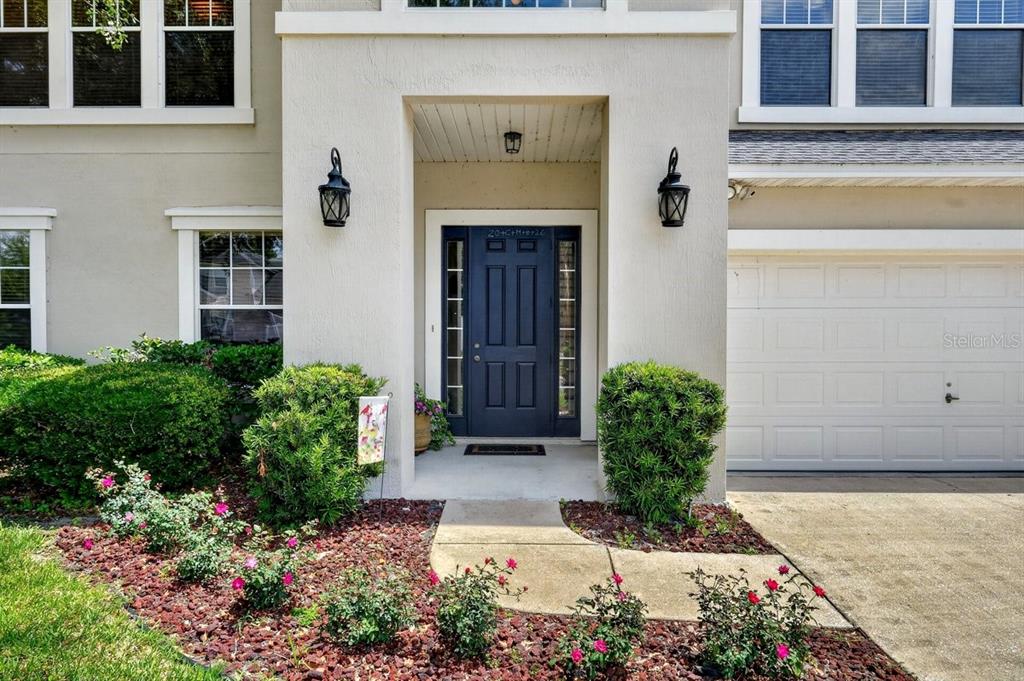 The exterior of a two-story home features a dark blue front door and landscaping — 3016 TOWER OAKS DRIVE, ORANGE PARK, FL