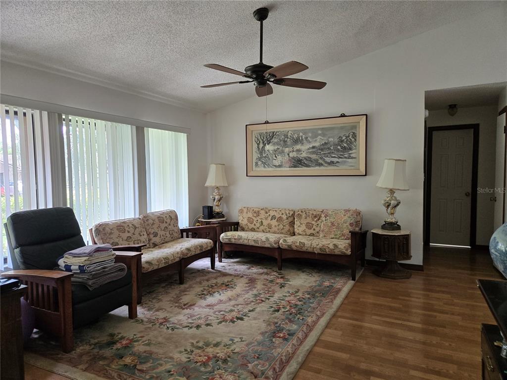 A living room features floral sofas, a patterned area rug, and a ceiling fan — 827 RILL DRIVE, ALTAMONTE SPRINGS, FL