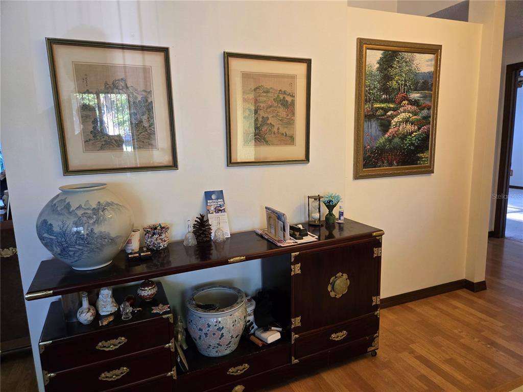 A wooden sideboard with Asian-style decor sits against a wall featuring three framed artworks — 827 RILL DRIVE, ALTAMONTE SPRINGS, FL