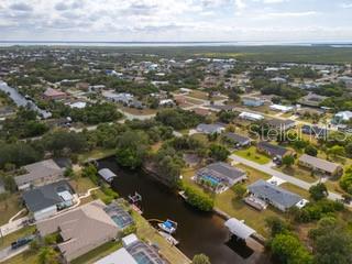 An aerial view shows a residential neighborhood with houses along a canal leading to water — 18262 VAN NUYS CIRCLE, PORT CHARLOTTE, FL