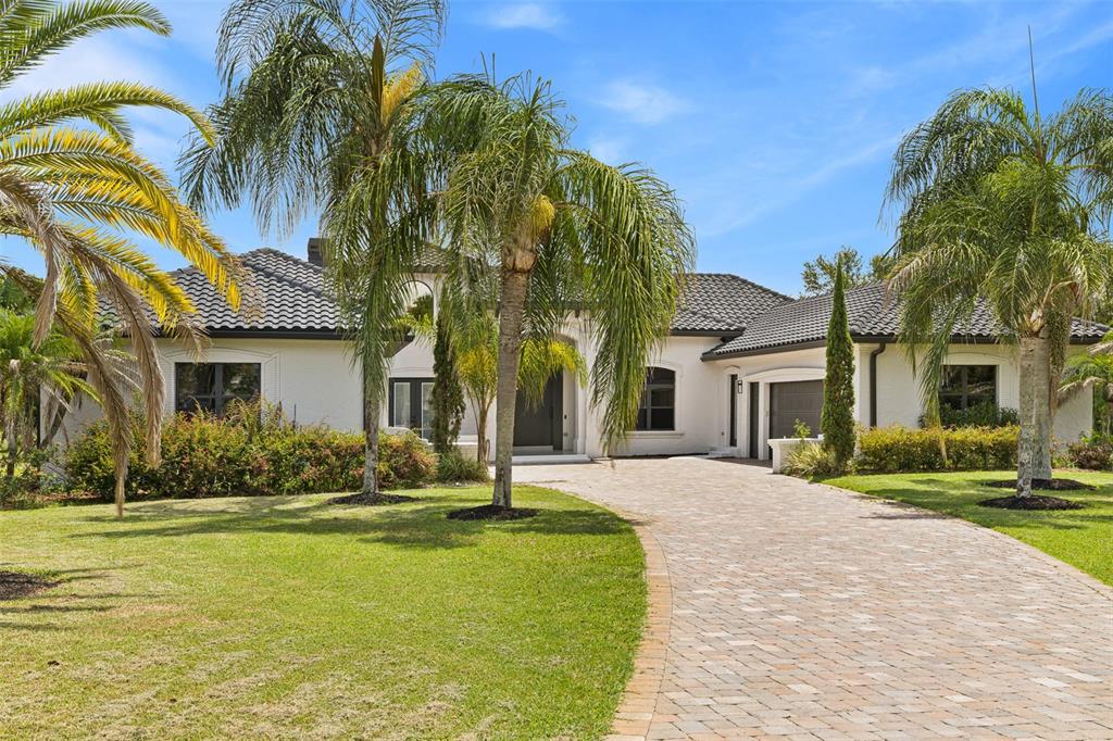 A single-story white stucco house with a tiled roof and a paved driveway — 10352 BURRIS COURT, ORLANDO, FL