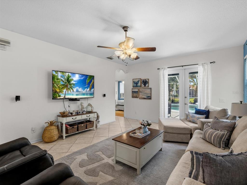 A living room features a television, a ceiling fan, a sectional sofa, and tile flooring — 21014 FOLLENSBY COURT, LAND O LAKES, FL
