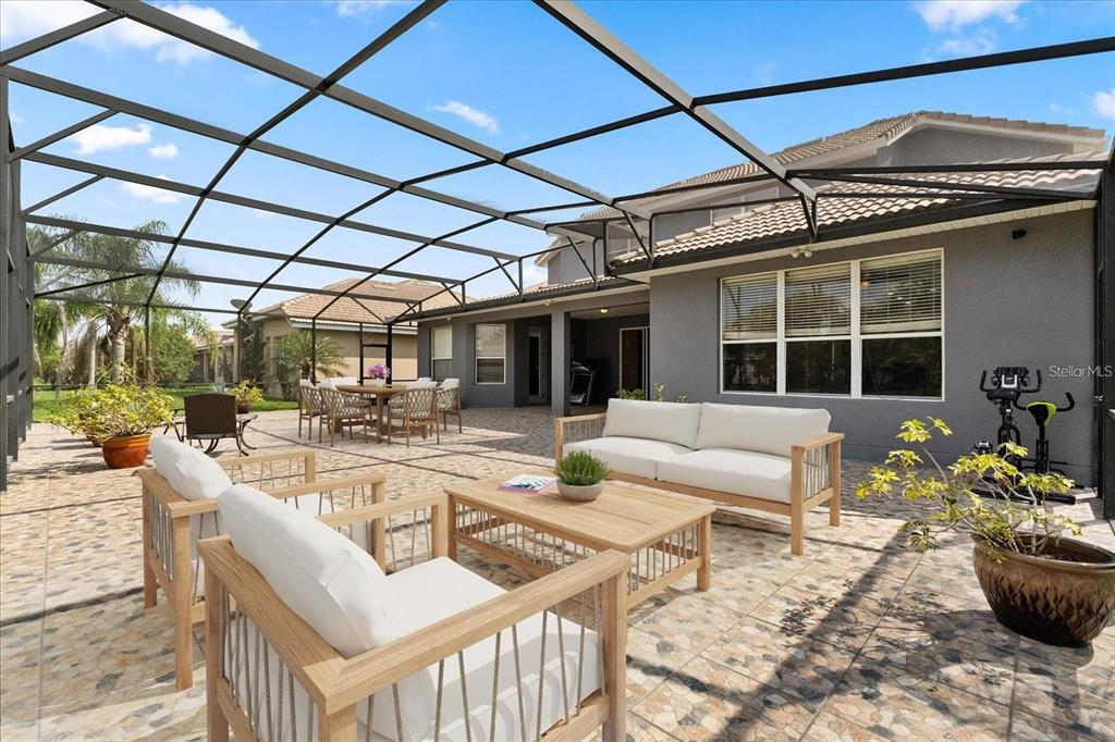 A screened-in patio features outdoor furniture, a tiled floor, and a view of the backyard — 3759 EAGLE ISLE CIRCLE, KISSIMMEE, FL