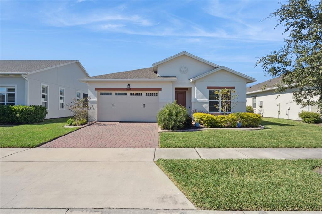 A single-story house with a brick driveway, two-car garage, and a landscaped front yard — 2632 MEADOWEDGE LOOP, ST CLOUD, FL