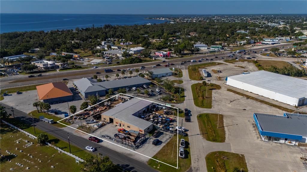 An aerial view shows a commercial building with an outdoor storage yard outlined in white — 4415 CHURCH STREET, PORT CHARLOTTE, FL