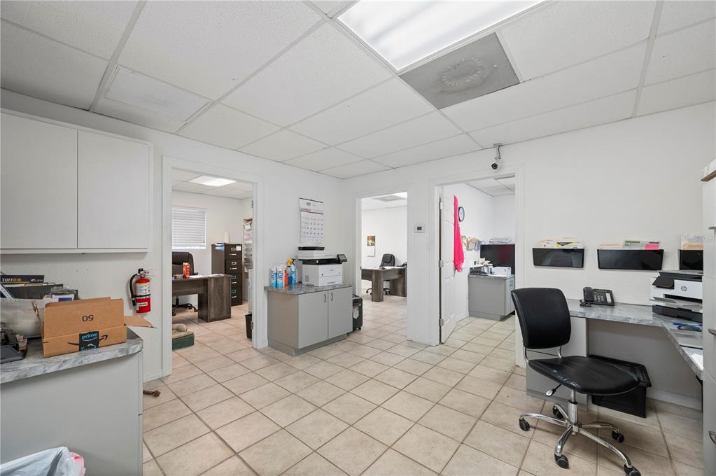 An office space features tiled floors, a drop ceiling, and multiple doorways leading to rooms — 4415 CHURCH STREET, PORT CHARLOTTE, FL