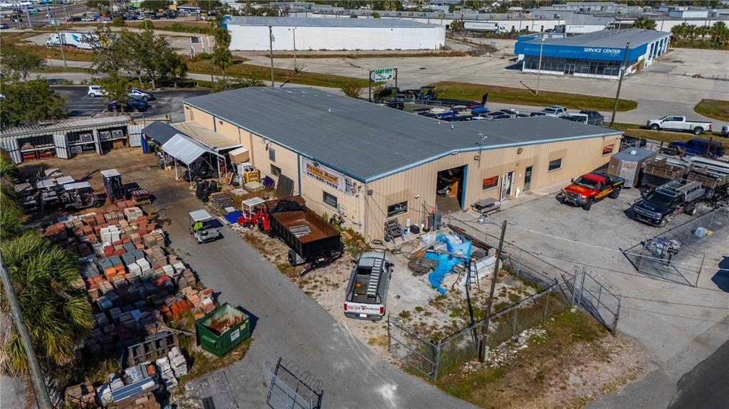An aerial view shows a commercial building with a metal roof and an outdoor storage yard — 4415 CHURCH STREET, PORT CHARLOTTE, FL