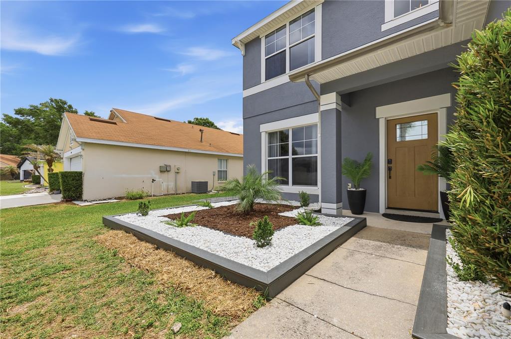 A gray two-story house features a front garden bed with white rocks and a palm — 3097 BUCKEYE POINTE DRIVE, WINTER HAVEN, FL