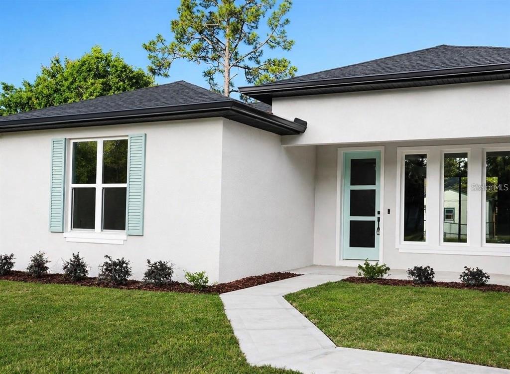A white stucco house with a light blue front door and matching window shutters — 14 RENSHAW DRIVE, PALM COAST, FL