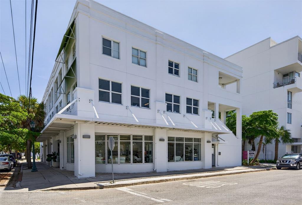 A three-story white commercial building with large ground-floor windows and a metal awning — 433 CENTRAL AVENUE, SARASOTA, FL