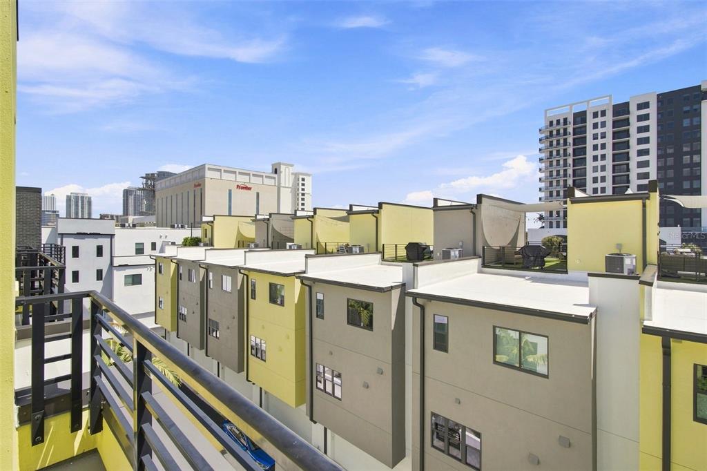 An elevated view of modern townhomes with flat roofs and balconies under a blue sky — 931 ARLINGTON AVENUE N, ST PETERSBURG, FL