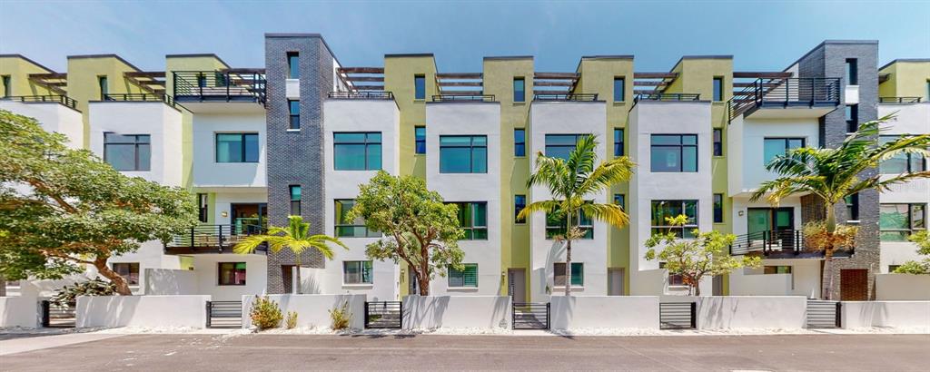 A row of modern multi-story townhouses with white walls, dark brick accents, and palm trees — 931 ARLINGTON AVENUE N, ST PETERSBURG, FL