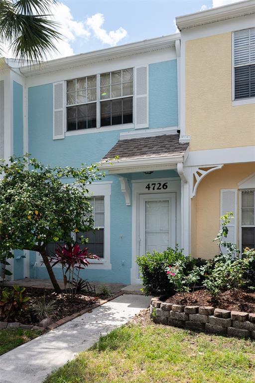 A two-story townhouse with blue stucco siding, a front walkway, and a small garden bed — 4726 SABAL KEY DRIVE, BRADENTON, FL