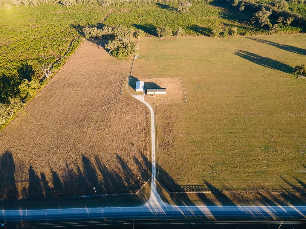 An aerial view shows a house and barn situated on a large, open rural lot — 3789 NW 202ND STREET, NEWBERRY, FL