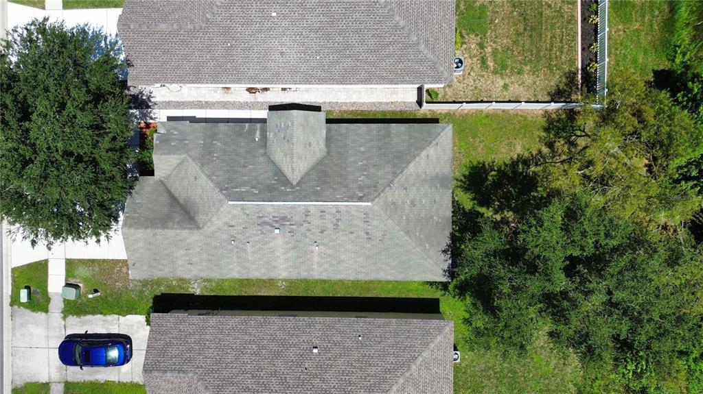 An aerial view shows the gray shingled roof of a house surrounded by trees — 12922 FIELDMOOR COURT, RIVERVIEW, FL