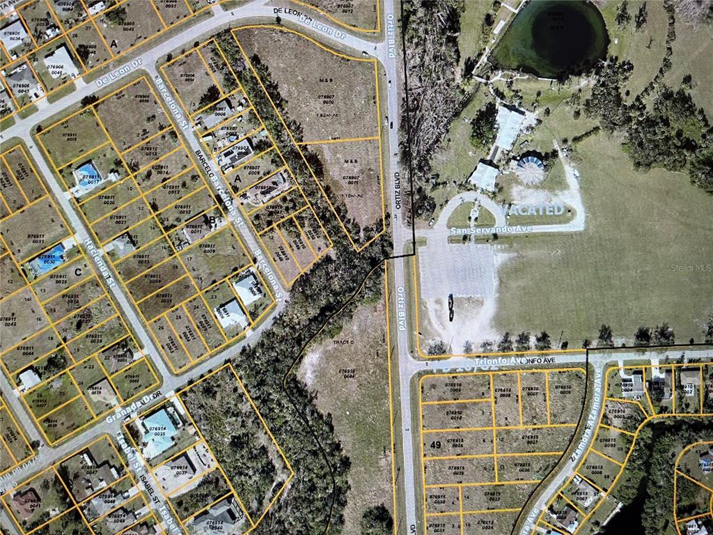 This is an aerial map showing residential lots, streets, and a large vacant area — LOT 13 BARCELONA STREET, NORTH PORT, FL