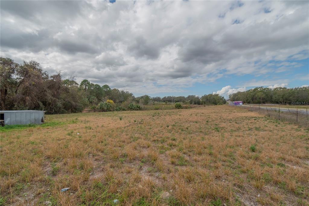 A wide, grassy, undeveloped lot under a cloudy sky with a small shed on the left — 46 A, SANFORD, FL