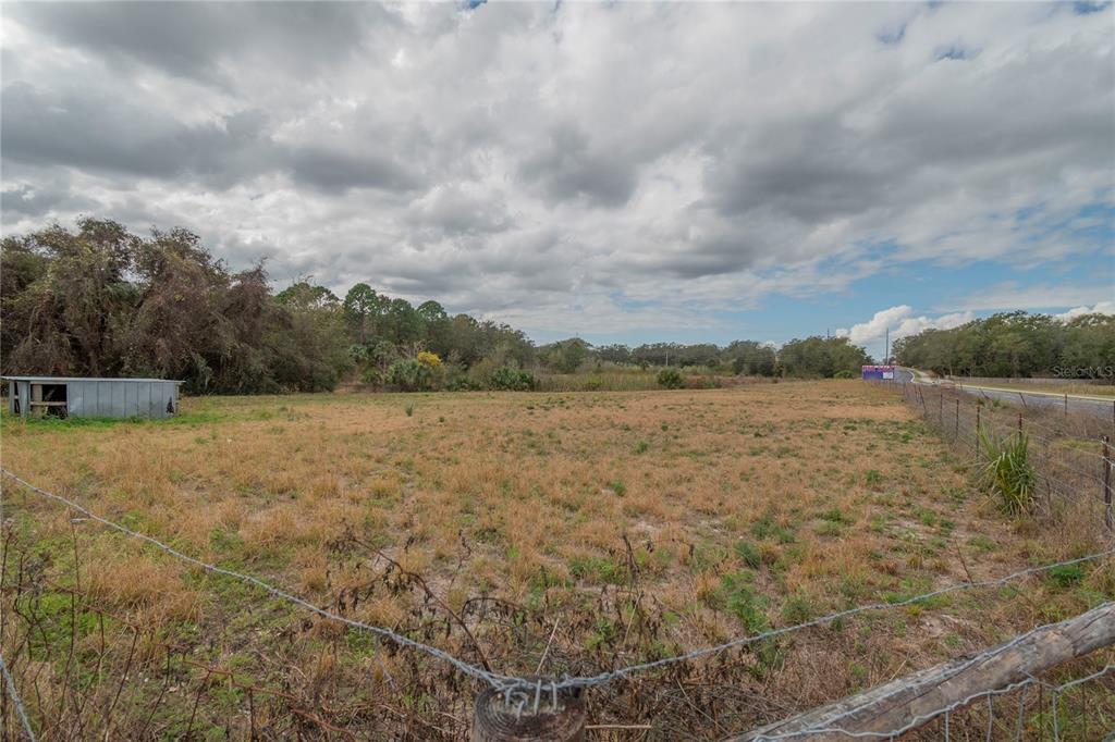 A wide, grassy, fenced-in vacant lot under a cloudy sky with a small shed — 46 A, SANFORD, FL